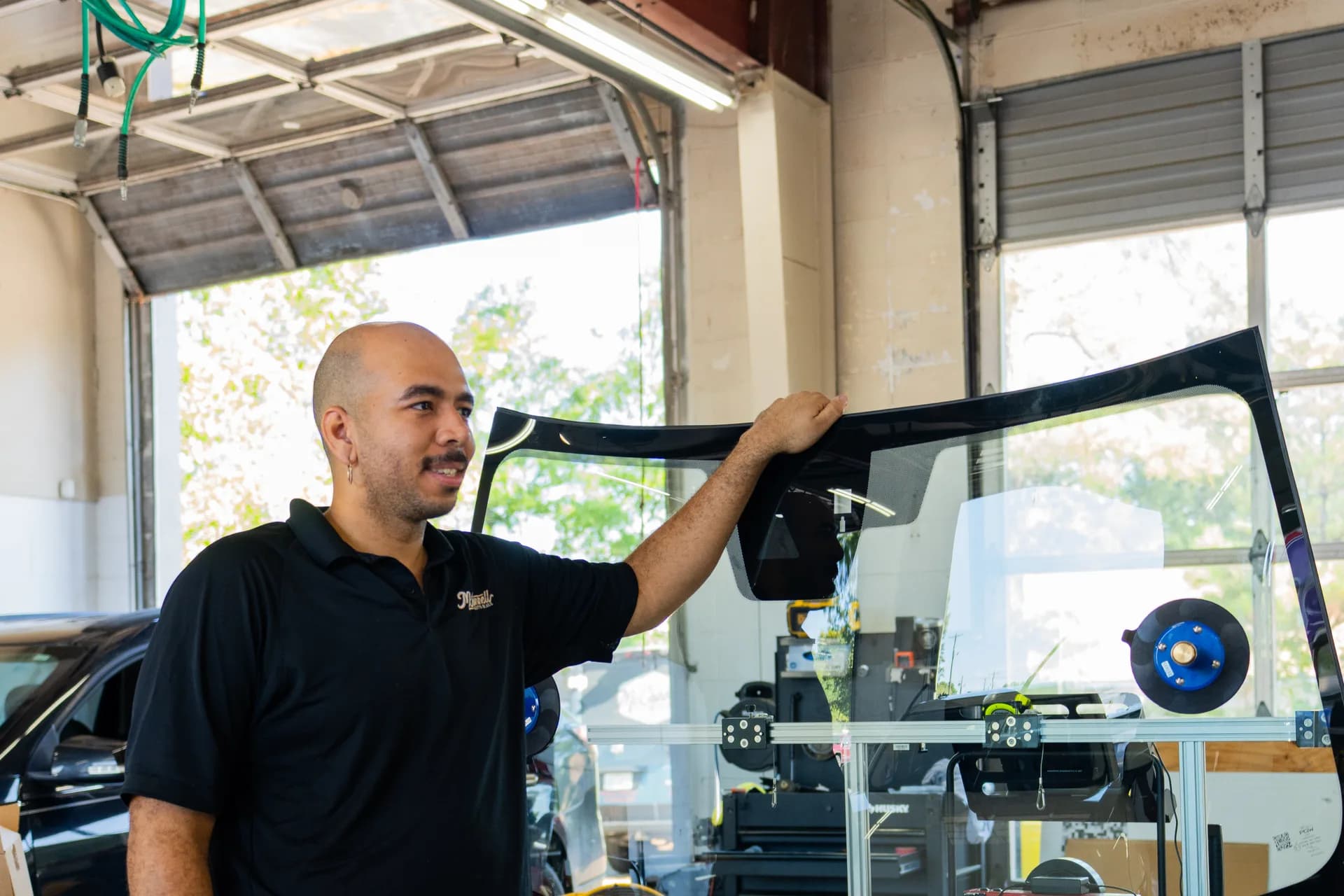 Technician checking side glass and trim inside the shop