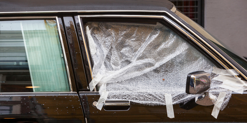 Broken car window covered with plastic in Rotterdam in the Netherlands